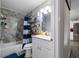 Well-lit bathroom with a tub-shower combo, marble-look tile and white vanity and lighting at 2804 Robinson Rd, Plant City, FL 33565