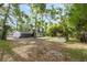 Spacious backyard featuring a large, screened porch, a detached garage, and mature trees at 6005 Ike Smith Rd, Plant City, FL 33565