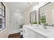 Updated bathroom with modern tile shower, dual sinks, and wood flooring at 6005 Ike Smith Rd, Plant City, FL 33565