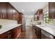 Modern kitchen features dark wood cabinets, stainless steel appliances, and white countertops at 6005 Ike Smith Rd, Plant City, FL 33565