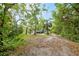 Secluded property entrance with mature trees offering natural shade and privacy to the home and grounds at 6005 Ike Smith Rd, Plant City, FL 33565