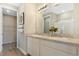 Bathroom with double vanity, large mirror, modern lighting fixtures, and access to a walk-in closet and separate shower room at 6014 Jensen View Ave, Apollo Beach, FL 33572