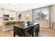 Open-concept dining area with sleek table, chairs, bar seating at kitchen island, and plenty of natural light from large windows at 6014 Jensen View Ave, Apollo Beach, FL 33572