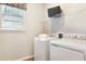 Efficient laundry room with modern washer and dryer, storage shelf, and a window for natural light at 6014 Jensen View Ave, Apollo Beach, FL 33572