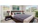 Comfortable bedroom with a queen bed, stylish lamps, and modern decor and beautiful light from two windows at 14010 102Nd Ave, Largo, FL 33774