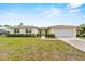 Charming single-story home featuring a two-car garage and manicured front lawn under a bright, sunny sky at 14010 102Nd Ave, Largo, FL 33774
