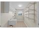 Functional laundry room with open shelving and tile flooring at 14010 102Nd Ave, Largo, FL 33774