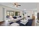 Living room with dark hardwood floors and sliding glass doors to lanai, staged with modern white furnishings at 14010 102Nd Ave, Largo, FL 33774