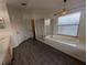 Bright bathroom with a separate glass shower and a soaking tub under a window with blinds at 16219 Turnbury Oak Dr, Odessa, FL 33556