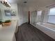 Spacious bathroom featuring a separate shower and tub, complemented by wood-look flooring at 16219 Turnbury Oak Dr, Odessa, FL 33556
