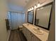 Bathroom showcasing a double sink vanity and a shower with a decorative shower curtain at 16219 Turnbury Oak Dr, Odessa, FL 33556