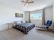 Bedroom with plush carpeting, ceiling fan, side tables, and a seating chair at 16219 Turnbury Oak Dr, Odessa, FL 33556
