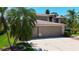 Spacious home with a three-car garage and mature palm trees in a landscaped yard at 16219 Turnbury Oak Dr, Odessa, FL 33556