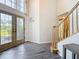 Elegant foyer with a staircase, wood floors, and a view of the front yard through glass doors at 16219 Turnbury Oak Dr, Odessa, FL 33556