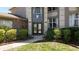 Inviting home entrance with double doors, large windows, and lush landscaping at 16219 Turnbury Oak Dr, Odessa, FL 33556