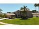 Beautiful front exterior featuring a well-manicured lawn, mature trees, and a three-car garage at 16219 Turnbury Oak Dr, Odessa, FL 33556