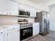 Modern kitchen with stainless steel appliances, white cabinets, and gray wood-look flooring at 16219 Turnbury Oak Dr, Odessa, FL 33556