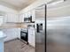 Well-lit kitchen with stainless steel appliances, white cabinetry, and modern flooring at 16219 Turnbury Oak Dr, Odessa, FL 33556