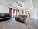 Bright living room with neutral tones, a ceiling fan, and luxury vinyl plank flooring at 16219 Turnbury Oak Dr, Odessa, FL 33556