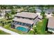 Aerial view of the home's rear, showcasing a screened pool, spacious yard, and well-maintained lawn at 16219 Turnbury Oak Dr, Odessa, FL 33556