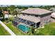 Back of home with a screened pool and spacious yard surrounded by lush greenery in a serene neighborhood at 16219 Turnbury Oak Dr, Odessa, FL 33556