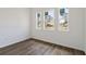 Bedroom featuring three windows and wood-look flooring at 4344 Jaslo Ave, North Port, FL 34286