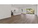 Open-concept living space with wood floors, white walls, and a view into the kitchen and back yard at 4344 Jaslo Ave, North Port, FL 34286