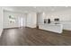 Bright, open-concept living space with hardwood floors flowing into a modern kitchen with white cabinets at 4344 Jaslo Ave, North Port, FL 34286