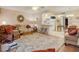 Well-lit living room featuring open floor plan, comfortable seating, laminate floors, ceiling fan and kitchen view at 219 S Mcmullen Booth Rd # 175, Clearwater, FL 33759