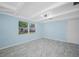 Airy bedroom with tile floors, blue walls, a ceiling fan, and large windows at 3728 19Th E St, Bradenton, FL 34208