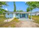 Charming blue single-story home with a covered patio, gravel, and green grass under a clear blue sky at 3728 19Th E St, Bradenton, FL 34208