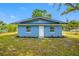 Charming front exterior highlighting the home's blue facade, white door, and neatly landscaped yard at 3728 19Th E St, Bradenton, FL 34208