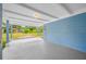 Spacious covered porch with a concrete floor, blue accent walls, and a white ceiling provides a comfortable outdoor space at 3728 19Th E St, Bradenton, FL 34208