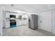 Bright kitchen featuring white cabinets, stainless steel appliances, light gray floor tiles, and modern fixtures at 3728 19Th E St, Bradenton, FL 34208