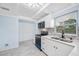Bright kitchen featuring white cabinets, stainless steel appliances, and a modern faucet with a gray tile backsplash at 3728 19Th E St, Bradenton, FL 34208