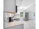 Modern kitchen with white cabinetry, a stainless steel refrigerator, and mosaic backsplash under beamed ceiling at 3728 19Th E St, Bradenton, FL 34208