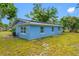 The home's exterior features a blue facade, complemented by well-maintained green grass and clear window views at 3728 19Th E St, Bradenton, FL 34208