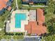 Aerial view of community pool with lounge chairs and tables, plus a clubhouse with a red tile roof at 18001 Richmond Place Dr # 126, Tampa, FL 33647