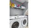 Laundry room with a Samsung washer and dryer, as well as a shelf above for storage and laundry supplies at 18001 Richmond Place Dr # 126, Tampa, FL 33647