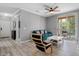 Bright living room featuring wood-look floors, modern ceiling fan, and access to a balcony with outdoor seating at 18001 Richmond Place Dr # 126, Tampa, FL 33647