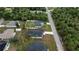 An aerial shot of a neighborhood showcasing cozy single Gathering homes amid lush palm trees and a paved street at 4146 New Milford St, North Port, FL 34288