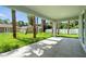 Covered back porch with a view of the spacious backyard and tropical landscaping at 4146 New Milford St, North Port, FL 34288