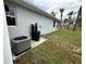 Backyard view showcasing modern AC unit, well pump, landscaping and home features at 4146 New Milford St, North Port, FL 34288