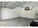 Spacious, unfinished garage with a high ceiling, overhead door hardware, and water heater at 4146 New Milford St, North Port, FL 34288