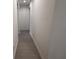 Long hallway with white walls and light floors. Includes a glimpse of the side of the house at 4146 New Milford St, North Port, FL 34288