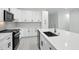 Modern kitchen with white cabinets, stainless steel appliances, and a large island with a breakfast bar at 4146 New Milford St, North Port, FL 34288