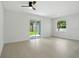 A bright and airy main bedroom with neutral colors, tile floors, and a sliding glass door to the outside at 4146 New Milford St, North Port, FL 34288