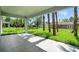 Covered outdoor patio with sleek tile flooring and lush backyard views with swaying palms at 4146 New Milford St, North Port, FL 34288