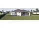 Backyard view of home with well-maintained green grass and outdoor seating at 4146 New Milford St, North Port, FL 34288