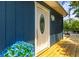 Inviting blue home featuring a decorative glass front door, stylish outdoor lighting, and wood deck at 5375 Circle Dr, Weeki Wachee, FL 34607